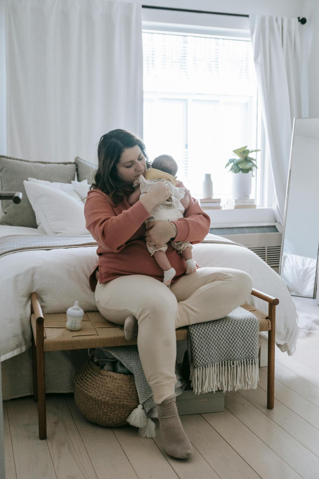 Mother gently holding her baby in a calm, peaceful moment at home